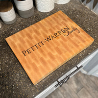 Cutting board with 'PETIT-WARREN Family' engraving on a kitchen counter.