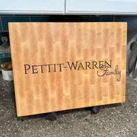 Wooden cutting board with inlaid text on a kitchen counter