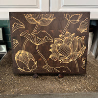 Wooden cutting board with floral designs on a kitchen counter