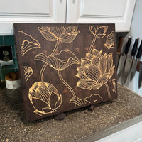 Wooden cutting board with floral patterns on a kitchen counter