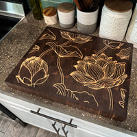 Wooden cutting board with floral designs on a kitchen counter